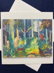 six by six inch card and envelope featuring a dark background with large moon. In foreground an unicorn and bird amongst shrubs and trees